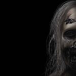 Peinture numérique au format horizontal 90×60 cm représentant un walker (zombie) de la série The Walking Dead en gros plan, visage décentré au tiers droit du cadre sur fond noir absolu, peau grise-beige tendue sur le crâne, cheveux longs blonds emmêlés, œil enfoncé fixe, plaie béante au-dessus du sourcil, mâchoire arrachée révélant dents et tendons, traitement abouti sans gore gratuit.