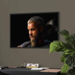 Peinture numérique réaliste de Ragnar Lothbrok de la série Vikings, regard intense et hache sur l'épaule, sur fond noir. Impression d'art Dibon mat.